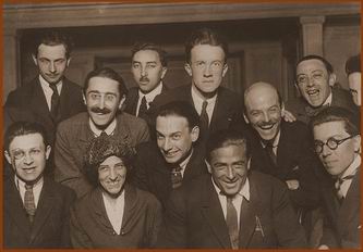 ...12 дада, лица слева направо. Верхний ряд: Louis Aragon, Theodore Fraenkel, Paul Eluard, Clément Pansaers, (Emmanuel Faÿ). Средний ряд: Paul Dermée, Philippe Soupault, Georges Ribemont-Dessaignes. Нижний ряд: Tristan Tzara (с моноклем), Celine Arnauld, Francis Picabia, André Breton....